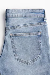 Pantalón de jean de tiro bajo, corte ajustado en cintura y muslos, y acampanado desde la rodilla hasta el ruedo. Confeccionado en denim ligeramente elástico. Cuenta con cierre y botón, bolsillos delanteros decorativos, bolsillo monedero y bolsillos traseros. Largo estándar.