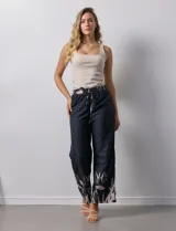 Pantalón negro con estampado de hojas color rosa en el ruedo y cintura elastizada con lazo ajustable.