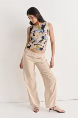 Pantalón largo de fibrana color beige, tiro alto con elástico fruncido en la cintura y pierna ancha.