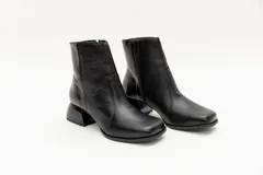 Botas cortas de cuero negro, con punta cuadrada y cierre lateral.