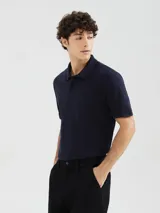 Camiseta tipo polo de manga corta, color azul oscuro, con cuello y tapeta de dos botones.