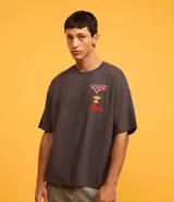 Remera gris de corte boxy, con cuello redondo y mangas cortas. Estampado frontal con logo de la película Cars, una copa y un auto.