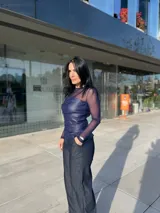 Top azul con mangas largas de tul y cuerpo de cuero sintético con drapeado horizontal en el busto.