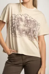 Remera color arena de algodón peinado con estampa frontal de texto con diseño floral.