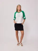 Remera bicolor Rusty con cuerpo verde lima y mangas ranglán grises con dos rayas blancas en los puños. Estampado frontal con el logo de la marca y el número 85.