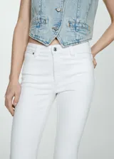 Pantalón de jean blanco, de corte flare, tiro alto y bajo desflecado. Confeccionado en tejido elástico de algodón reciclado.