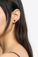 Caravanas circulares en tono dorado con un corazón central y letras de colores grabadas en el borde. Cuentan con cierre de gancho y están confeccionadas en latón con detalles esmaltados.