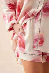 Short de lino color crudo con estampado de flores rosas y rojas. Tiene cintura elastizada y detalle de calado en el ruedo.