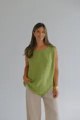 Musculosa verde pistacho de lino italiano, de corte recto, con caída fluida, escote redondo y ruedo asimétrico.