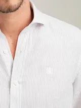 Camisa celeste a rayas verticales de lino, corte regular fit, cuello italiano, cierre con botones, manga larga terminada en puño simple y logo bordado en el pecho.