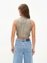 Chaleco corto gris con cierre frontal, cuello alto y bolsillos con cierre.