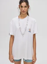 Remera amarilla de corte cuadrado y holgado, con estampado de estrella plateada con borde negro en el frente.