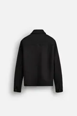 Sobrecamisa color beige de corte recto, con cuello solapa, manga larga con puños abotonados, cierre frontal abotonado, bolsillos de parche con solapa en el pecho y bolsillos de ojal en la cadera.
