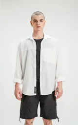 Camisa blanca de manga larga con bolsillo con ojal y botón en delantero, de calce oversize confeccionada en textil plano fresco y liviano.