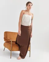 Top strapless color crema, con forro y elástico en el busto para sujetar, y mini tajos laterales.