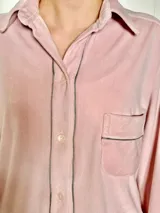 Pijama celeste de terciopelo, compuesto por una camisa de manga larga con botones y vivo blanco, bolsillo en el pecho y un pantalón recto con elástico en la cintura.