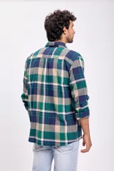 Camisa de franela a cuadros en tonos verde, azul y beige, con dos bolsillos frontales con solapa abotonada.
