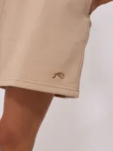 Short color beige de tiro alto, con cintura elástica y bordado en el frente.