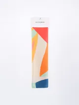 Pañuelo rectangular con estampado abstracto en tonos terracota, negro, blanco y beige.