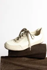 Zapatillas deportivas verde oliva con cordones y suela marrón.