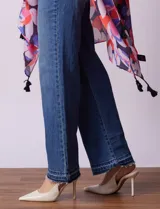 Kimono tejido con estampado floral multicolor y terminación de ruedo con borlas negras.