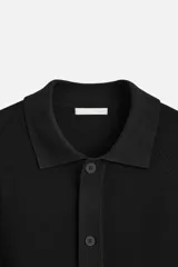 Cárdigan negro de punto con cuello solapa, manga larga y cierre frontal con botones. Tejido con hilatura de viscosa y acabado en rib.