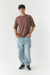 Remera gris oscuro de corte amplio con logo y arte estampado en el frente.