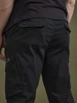 Pantalón cargo negro con bolsillos laterales con solapa, corte ajustado y tobillos elastizados.