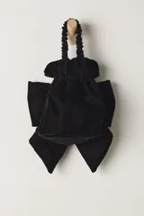 Bolso de terciopelo negro, estilo saco o fruncido, con un gran lazo decorativo en el frente. Posee una correa de hombro ajustable con herrajes dorados.
