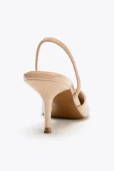 Zapato destalonado color beige acharolado, con escote en pico, tira trasera ajustable y tacón fino.