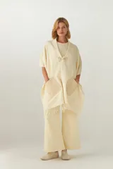 Chal de lana fina sin teñir, con calce en hombros, abrochadura con alamar de fieltro, bolsillos de cuero y terminación con flecos. Diseño exclusivo de Don Baez, hecho en Uruguay.