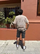 Remera color marrón con estampa en la espalda de una escena de playa.