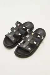 Sandalias negras con plataforma y tiras gruesas con apliques de tachas piramidales plateadas.