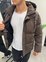 Campera puffer marrón de nylon impermeable con capucha forrada con corderito desmontable, cierre frontal con cremallera y broches a presión, y bolsillos laterales con cierre.