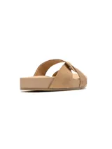 Sandalias bajas color beige con tiras cruzadas y detalle de nudo en el empeine.