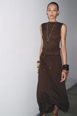 Top marrón de tejido de punto, sin mangas, con cuello fluido y detalle drapeado.