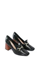 Zapato mocasín negro con estampado de cocodrilo, detalle metálico dorado y tacón geométrico de madera.