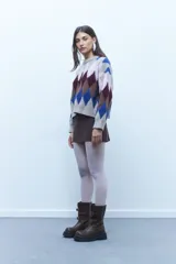 Sweater de poliéster con diseño de rombos en tonos beige, azul, marrón y borgoña.