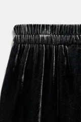 Pantalón de terciopelo negro de tiro medio con cintura elástica, bolsillos laterales ocultos y pierna ancha.