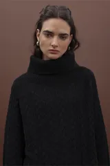 Sweater color verde claro con cuello alto y tejido de punto trenzado.