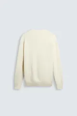 Jersey color crema de punto perlado, con cuello redondo, manga larga y corte regular fit.