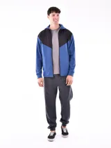 Campera deportiva azul con paneles negros en la parte superior y capucha. Cierre frontal con cremallera.