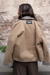 Cazadora color beige con apliques de pedrería y detalles en color marrón.