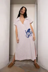Túnica de lino a rayas verticales color lila y blanco, con cuello polo y bordado de un pulpo azul en el frente.