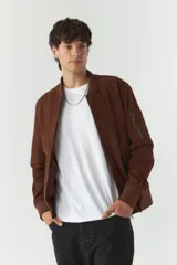 Campera de poliéster simil gamuza color negro, con puños y cierre frontal.