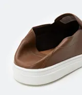 Championes slip on marrones de cuero, con talón flexible y suela blanca.