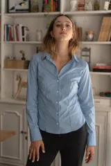 Camisa clásica entallada de color blanco, con cierre frontal y mangas largas.