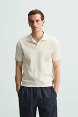 Polo azul marino de punto con textura acanalada vertical, corte regular fit, cuello solapa con abertura frontal y mangas cortas.