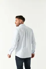 Camisa oxford celeste con rayas verticales blancas, de manga larga y corte regular. Tiene cuello abotonado, bolsillo en el pecho y logo bordado.