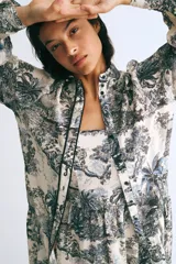 Vestido midi con breteles finos, escote cuadrado y espalda fruncida. Presenta un estampado de tigres, elefantes y vegetación en tonos azules sobre fondo blanco.